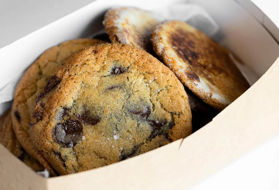 Chocolate chip and crème brûlée cookies in a paper-lined box