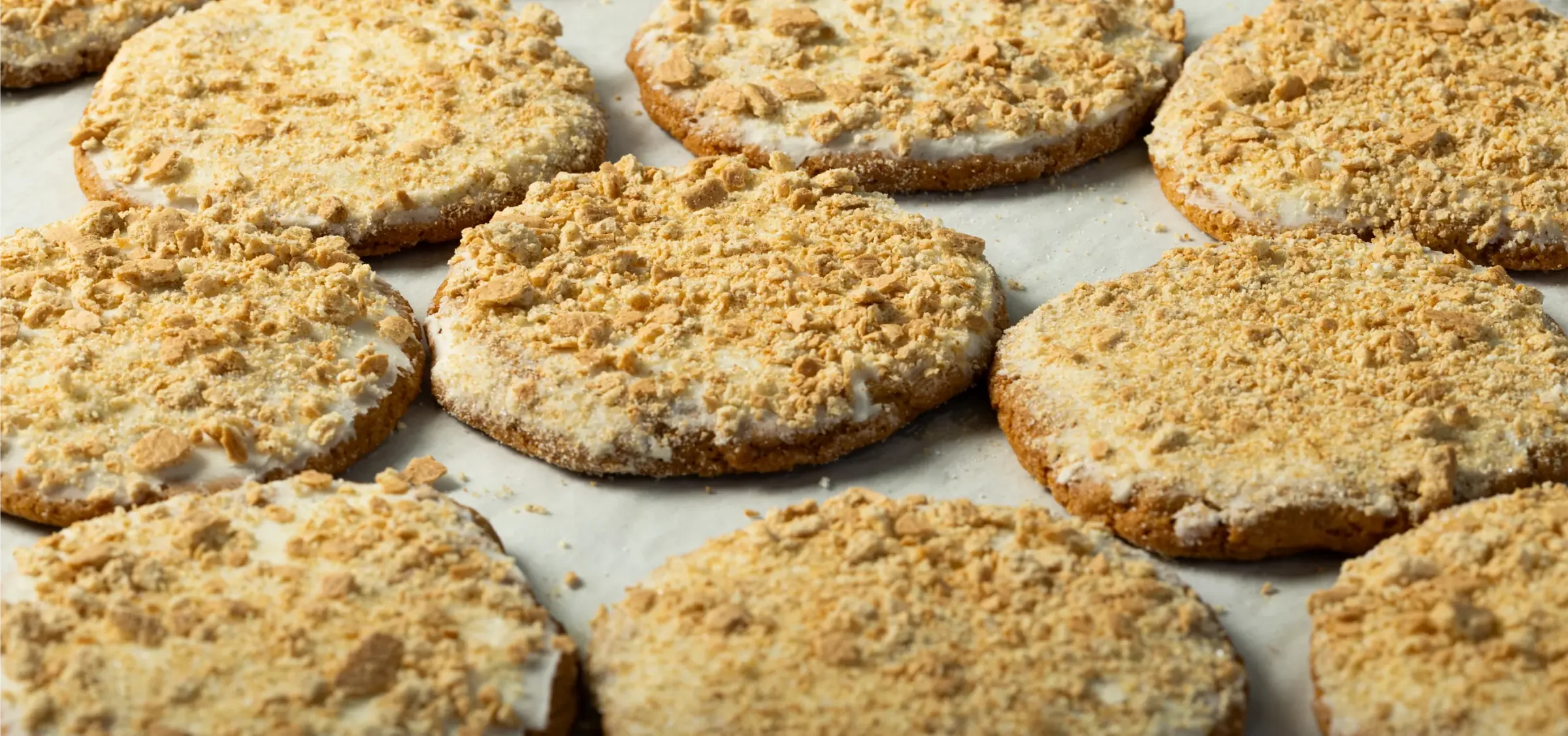 Rows of frosted cookies on a bakery tray
