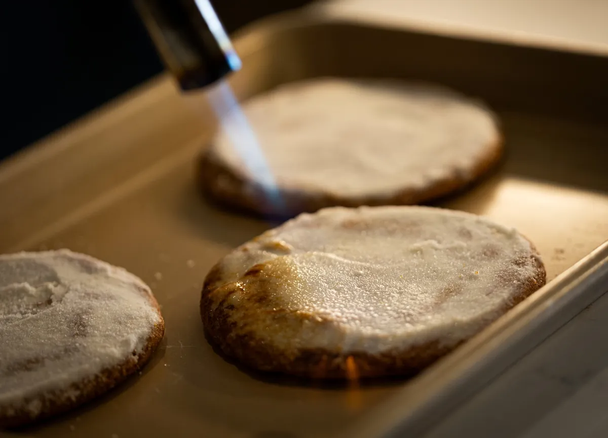A kitchen torch caramelising crème brûlée cookies