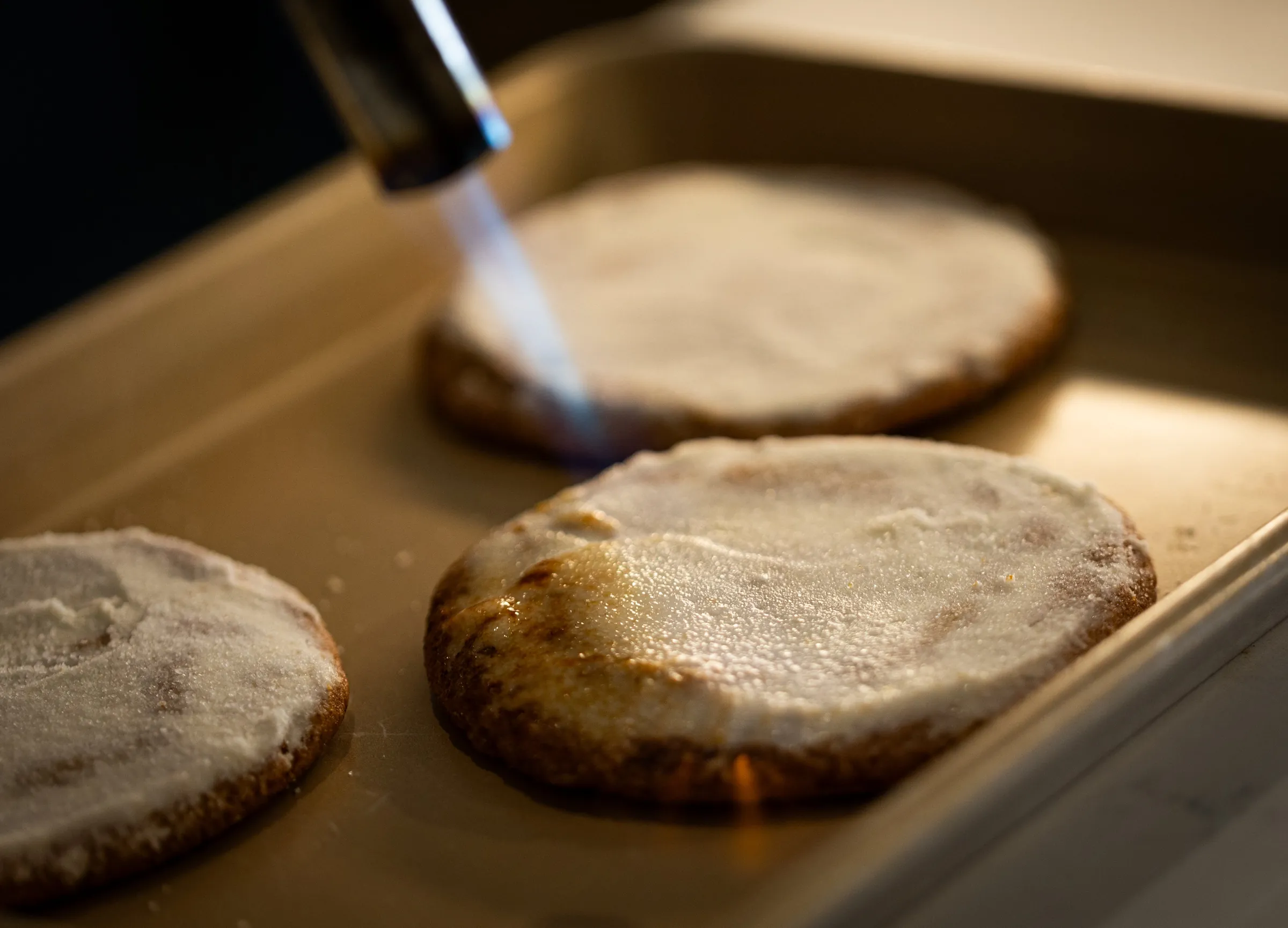 A torch caramelizing the top of a cookie